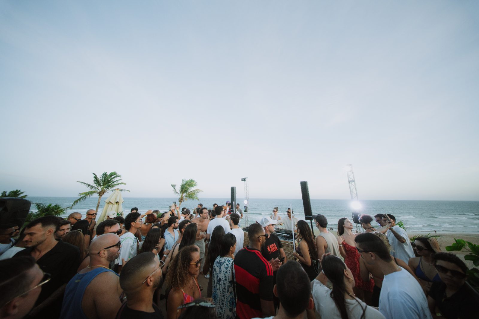 Pôr do sol e coqueiros em day party da Drop